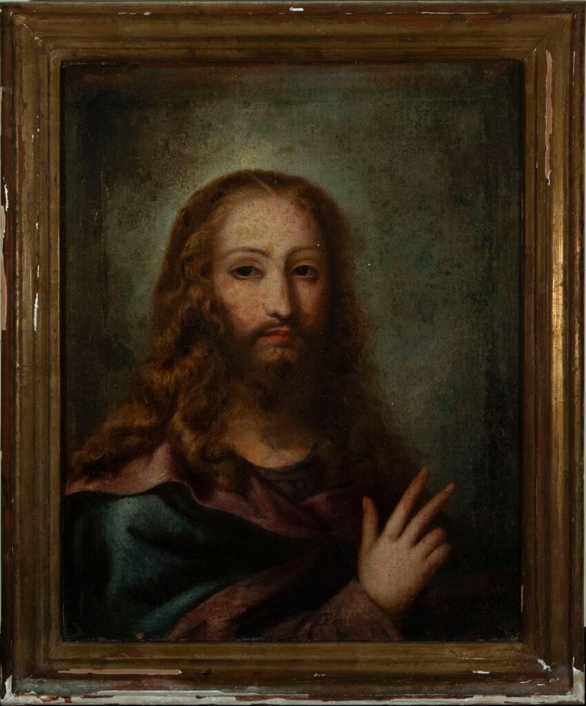17th-century Mexican Colonial painting of Cristo Salvator Mundi depicting Christ with a serene expression, long flowing hair, and raised hand in blessing, framed in an aged wooden frame.